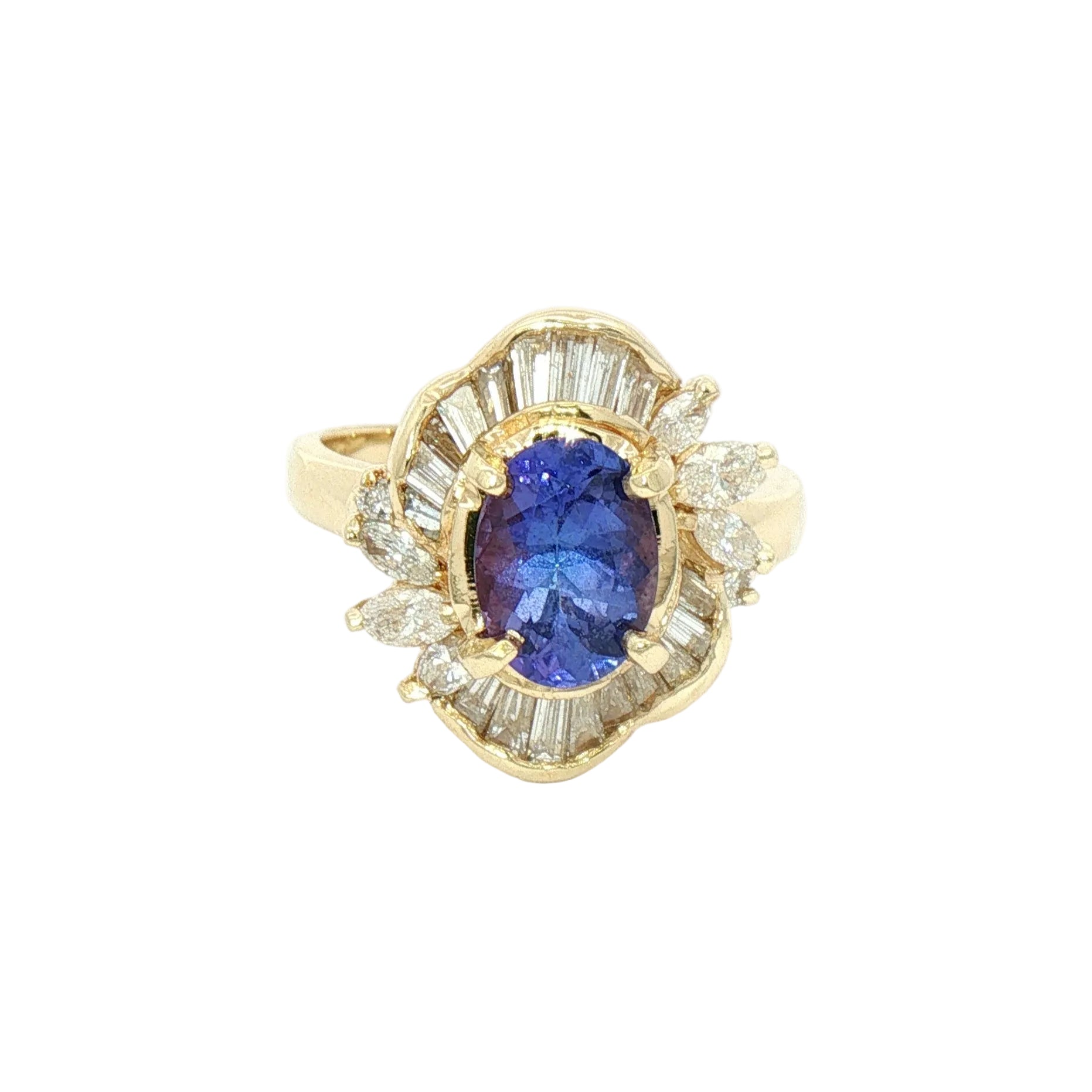 A yellow gold ring featuring an oval-cut tanzanite center stone surrounded by a halo of baguette and round clear stones.