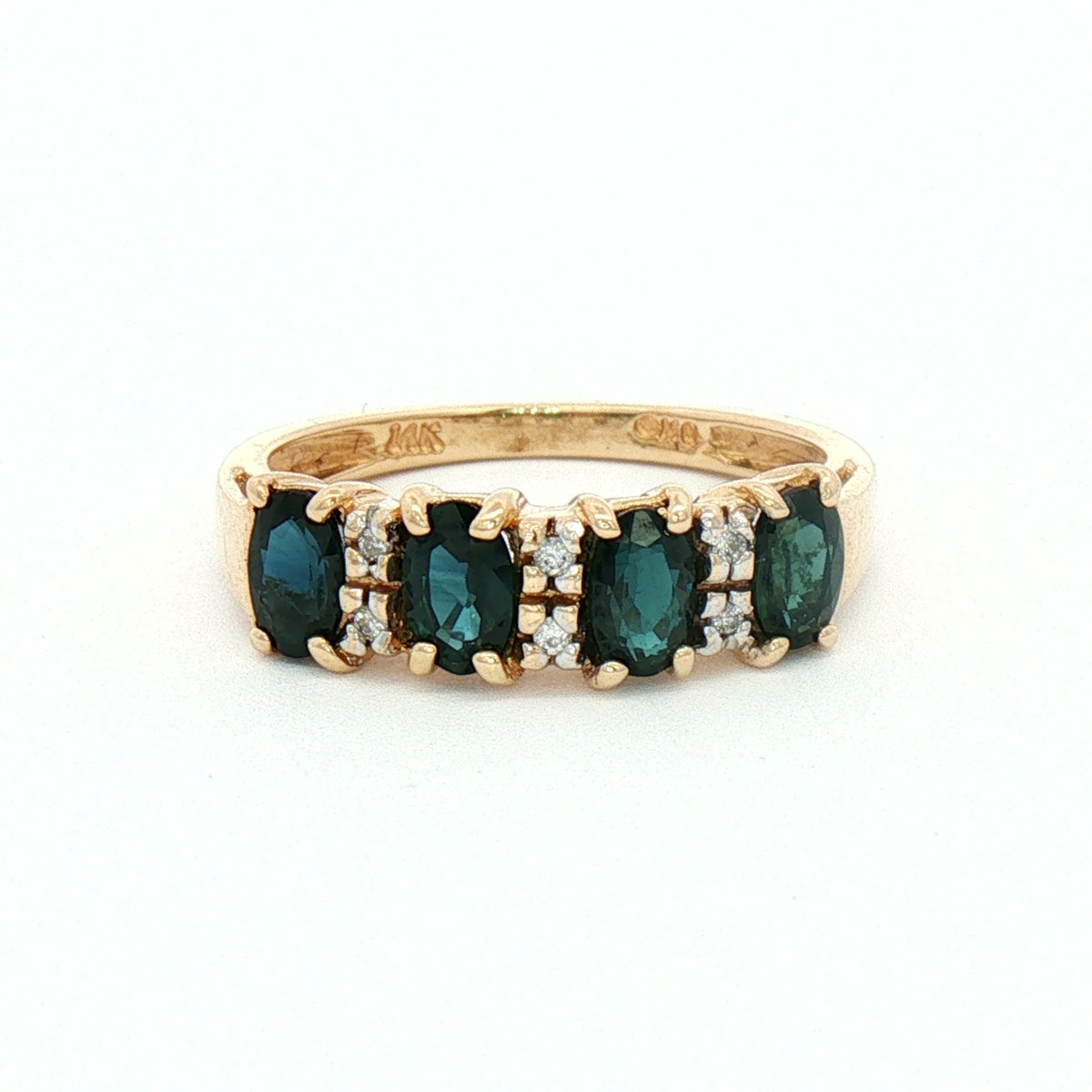 A yellow gold ring featuring four marquise-cut blue sapphires set with small round diamonds.