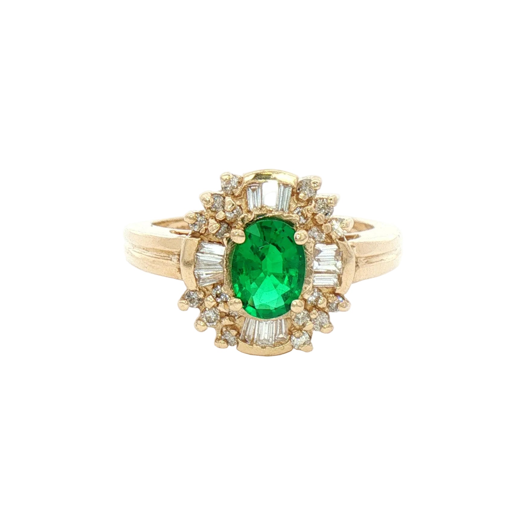 A yellow gold ring featuring an oval-cut green emerald center stone surrounded by a halo of baguette-cut and round-cut clear stones.
