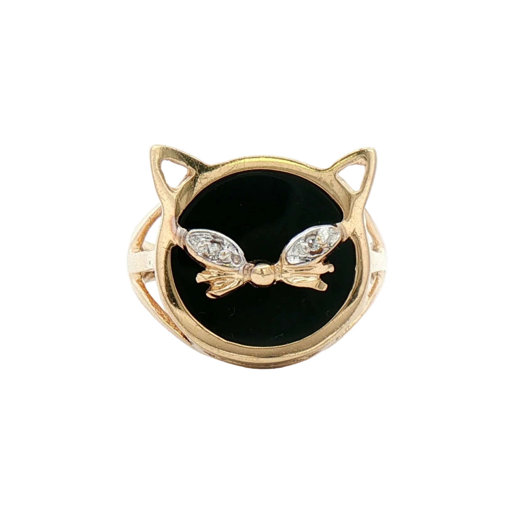 A gold cat-head ring featuring a black onyx face, detailed with a gold bow and two small clear gemstones on the eyes.