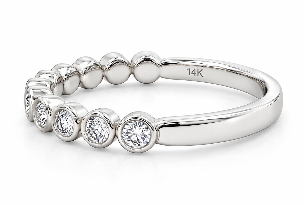 A white gold tennis-style band ring featuring a row of bezel-set round diamonds on the front.