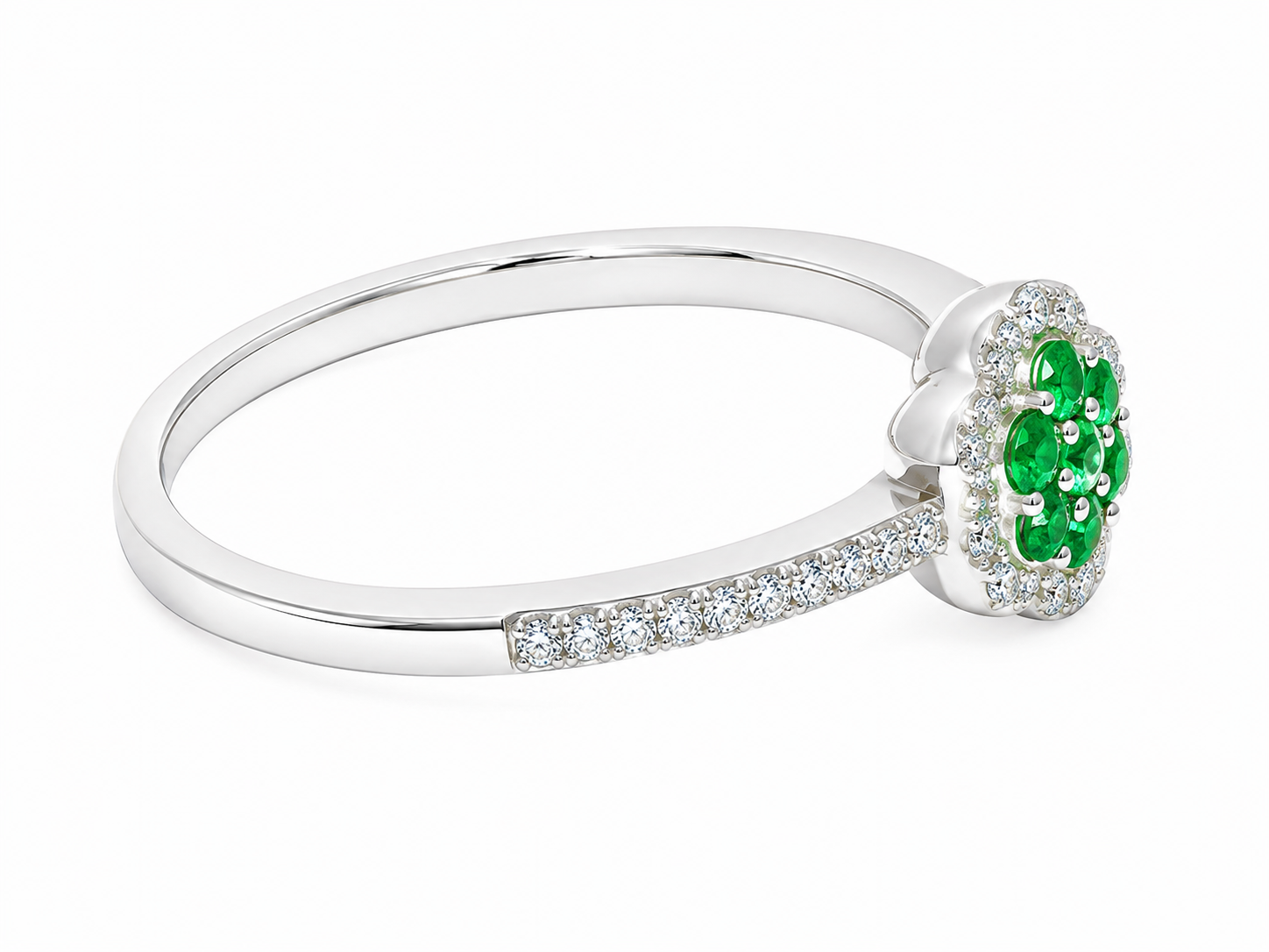 A white gold ring featuring a round cluster of vibrant green gemstones surrounded by small clear stones, with a pavé-set silver band, shown on a white background.