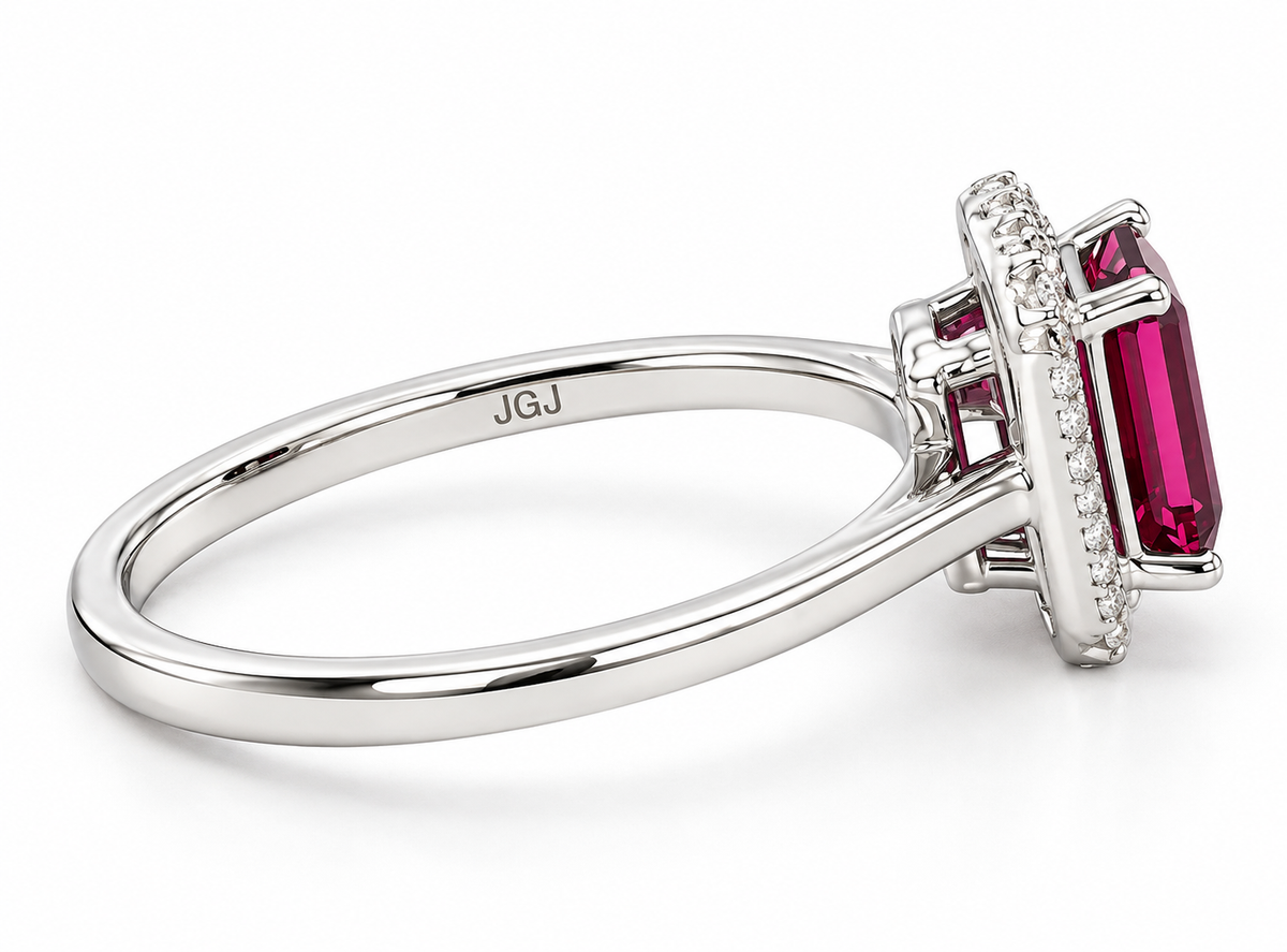 A white gold ring featuring a large emerald-cut pink gemstone in a halo setting with smaller round stones, shown on a white background.