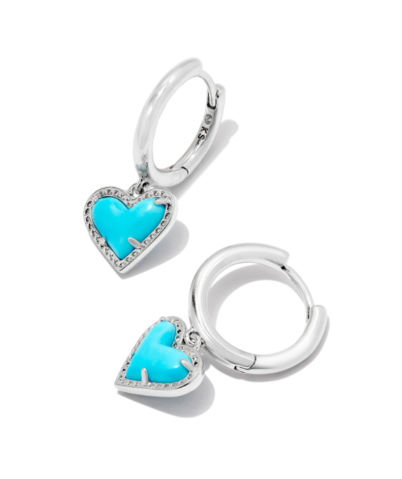 Two Kendra Scott Ari Heart Huggie Earrings in silver with dangling turquoise magnesite heart charms.