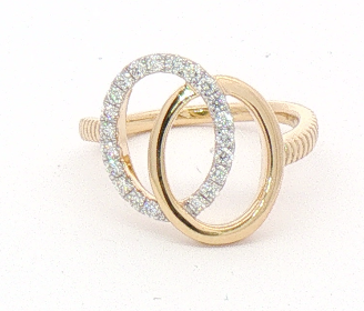 A gold ring featuring two interlocking oval designs, with one oval encrusted with small clear stones, set against a plain white background.