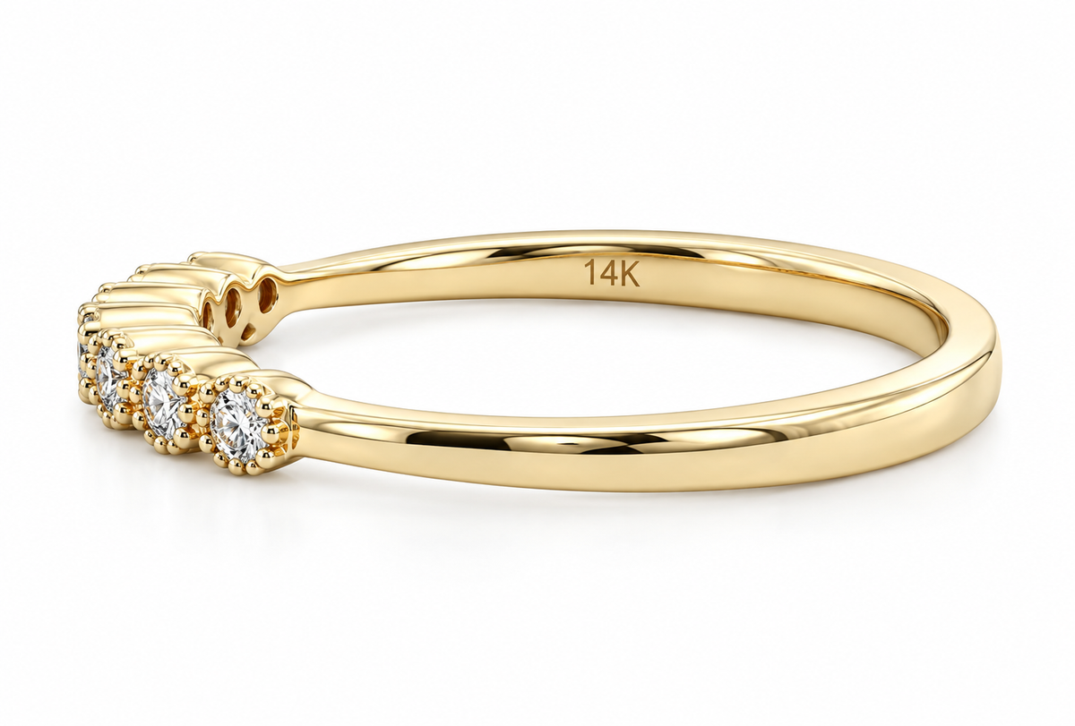 A polished yellow gold ring with a curved band, featuring a row of small round-cut clear gemstones.