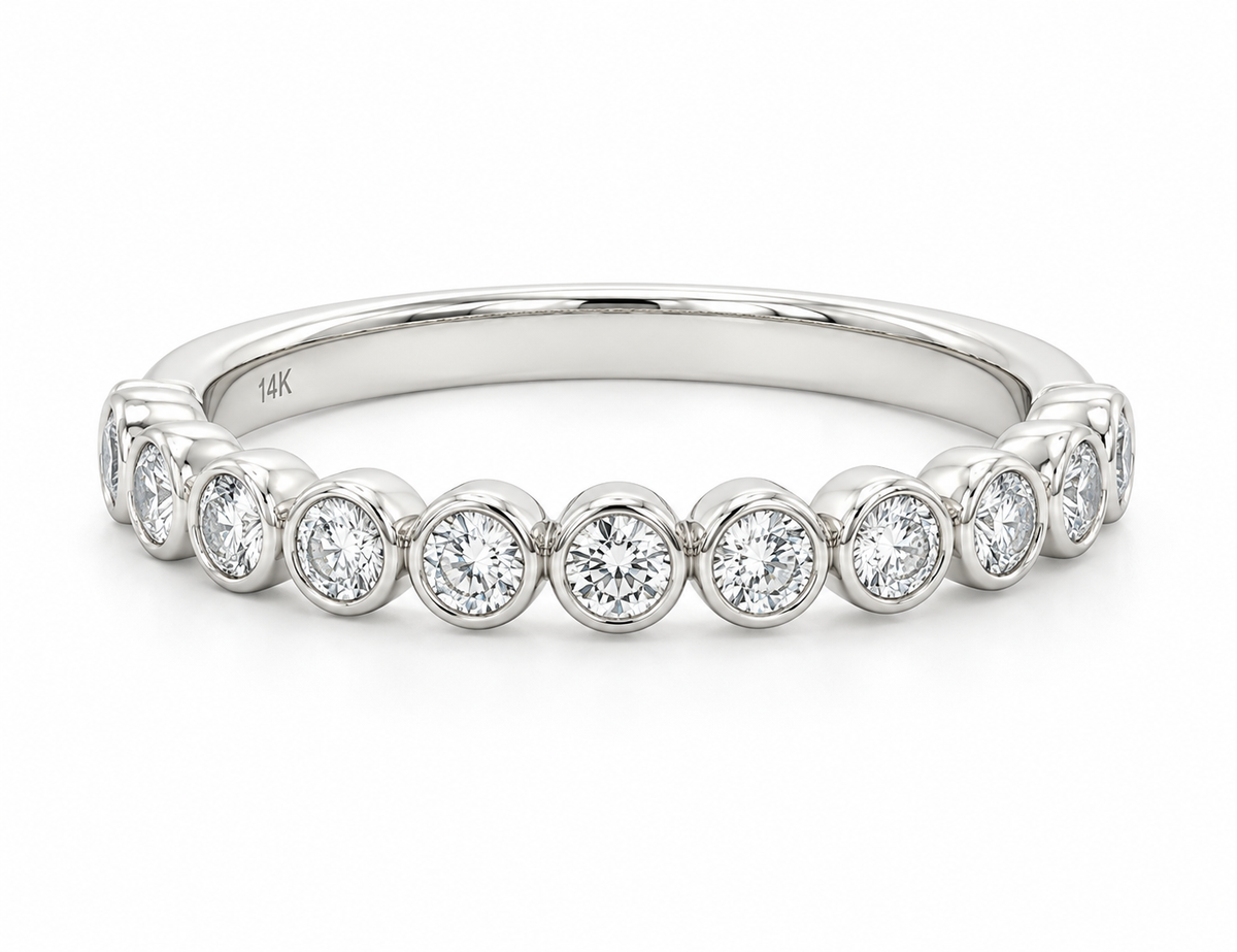 A white gold diamond eternity band ring featuring a row of round-cut diamonds set in a polished silver band.