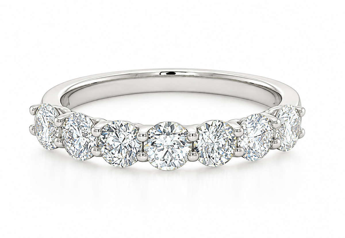 A diamond eternity ring in a polished white gold or platinum band, set against a clean white background.