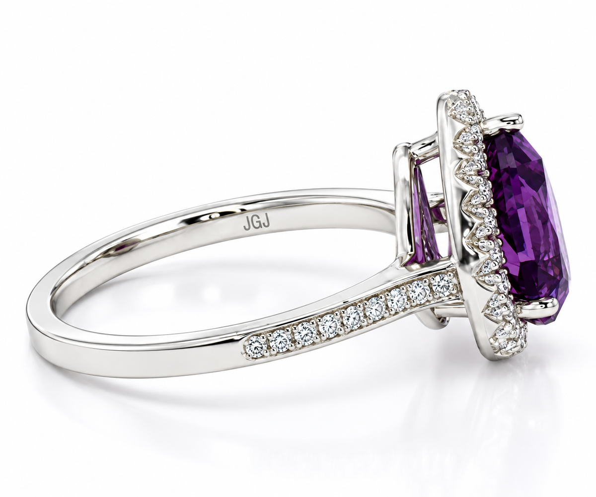 A white gold diamond ring featuring a large oval purple amethyst center stone, two smaller baguette-cut purple amethyst stones, and a halo of small round diamonds. The band is decorated with a row of small round diamonds.