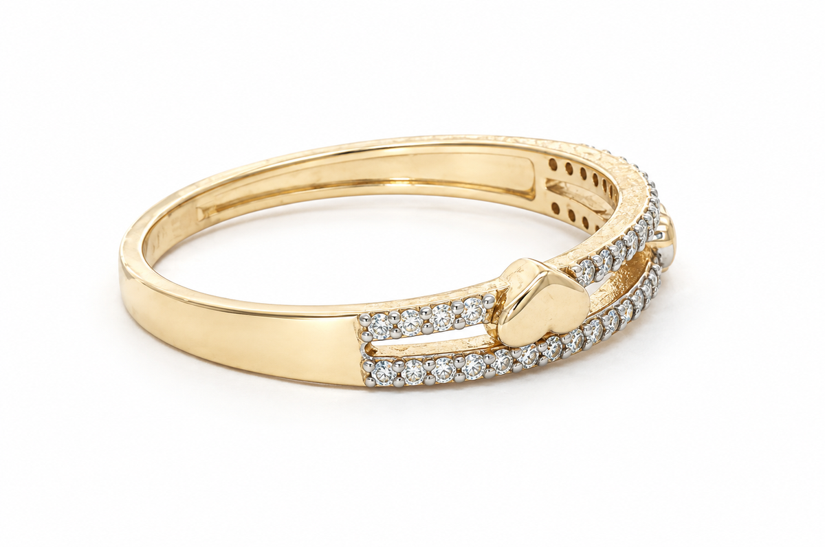 A yellow gold bangle bracelet featuring a heart-shaped clasp and pavé-set clear stones, shown on a plain white background.