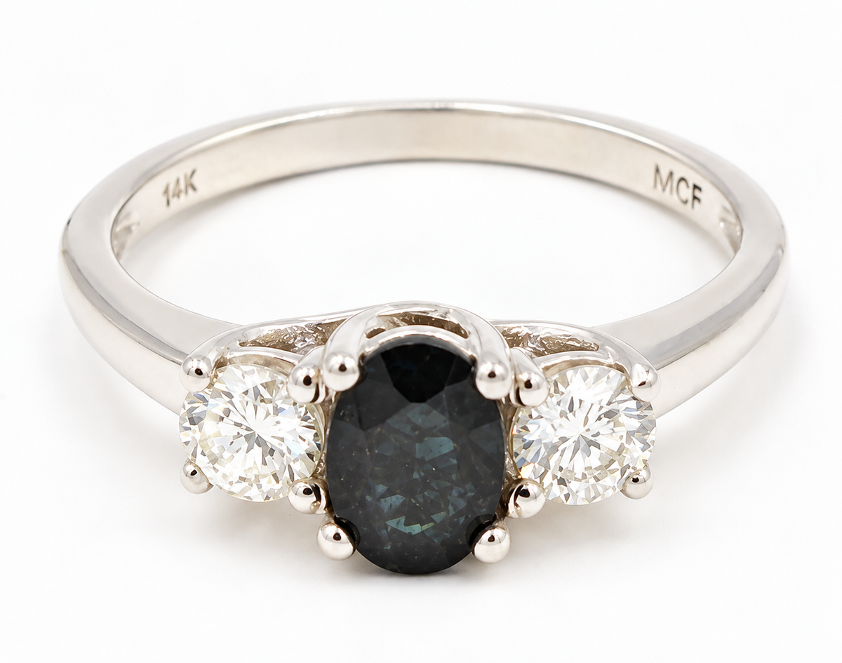 Kent Island Jewelry 14k white gold three-stone ring with a central oval blue sapphire flanked by two round diamonds.