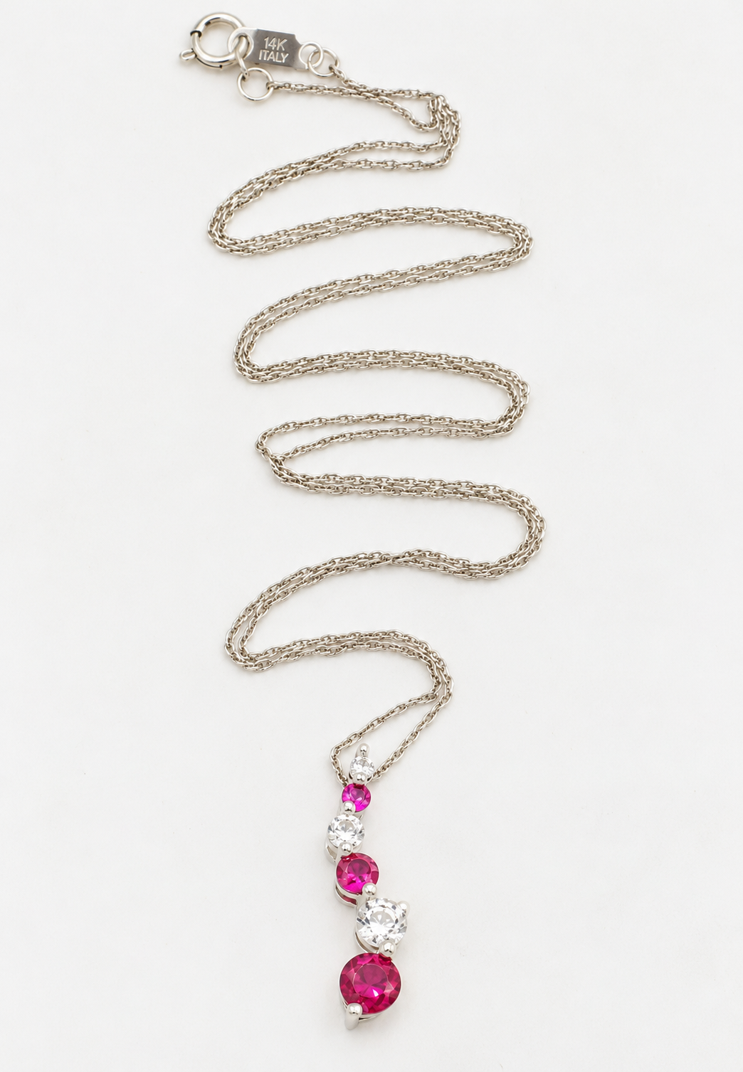 Kent Island Jewelry 10k White Gold White Sapphire & Pink Spinel necklace with a pendant of round gemstones on a rope chain.