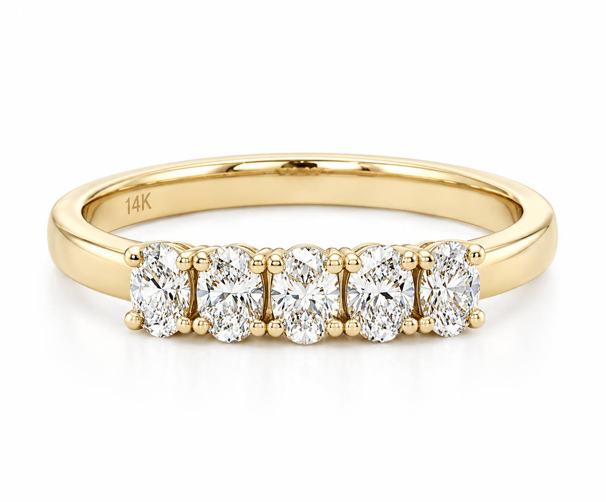 A yellow gold five-stone diamond ring with oval-cut diamonds set in a row on a polished band, shown on a clean white background.