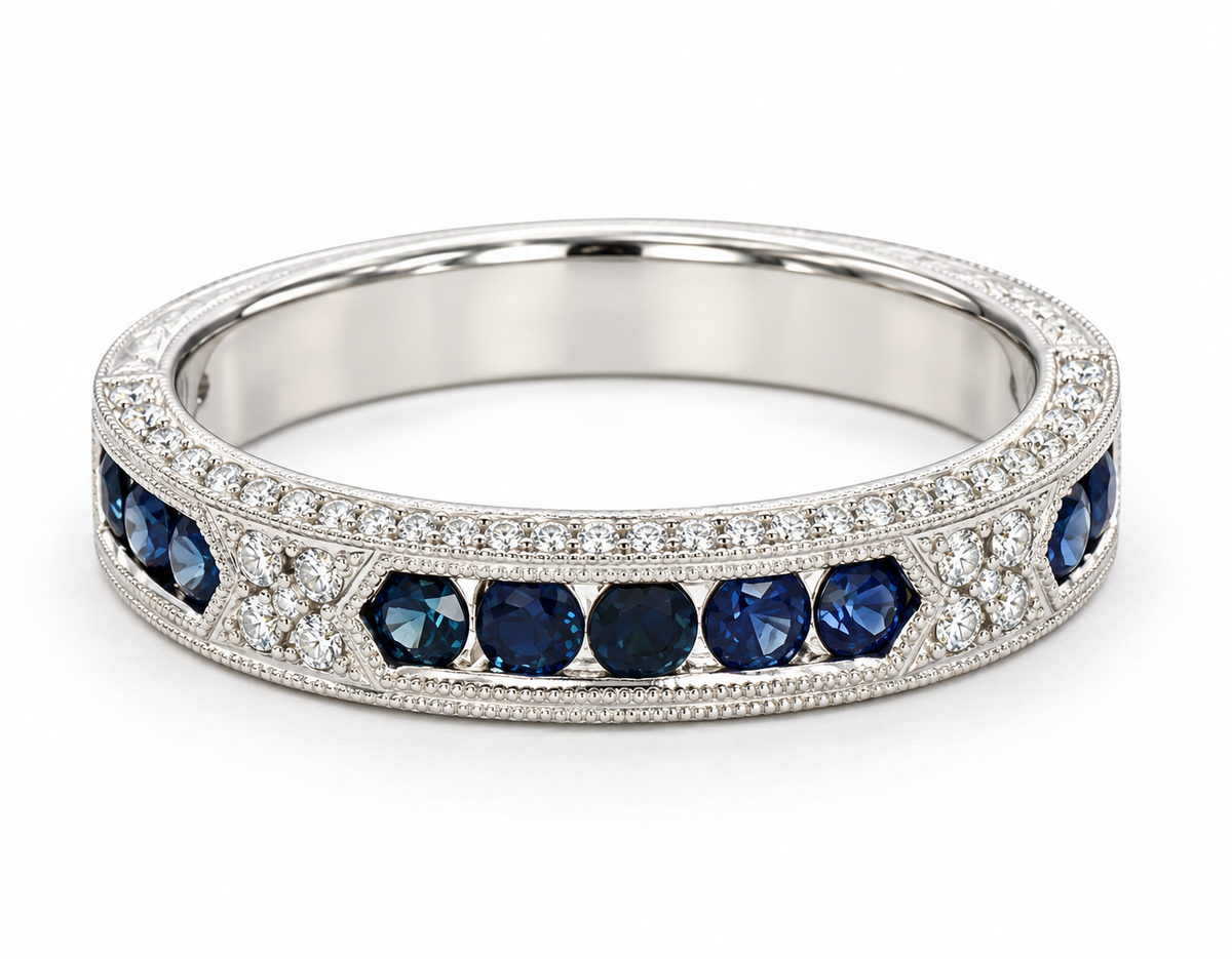 A white gold ring featuring a row of round-cut deep blue sapphires and pavé-set clear stones, shown on a clean white background.