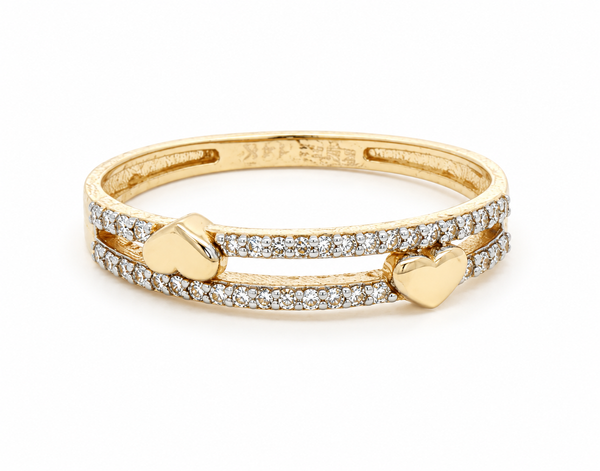 A yellow gold double-band ring featuring pavé-set clear stones and two polished gold heart charms, shown on a clean white background.