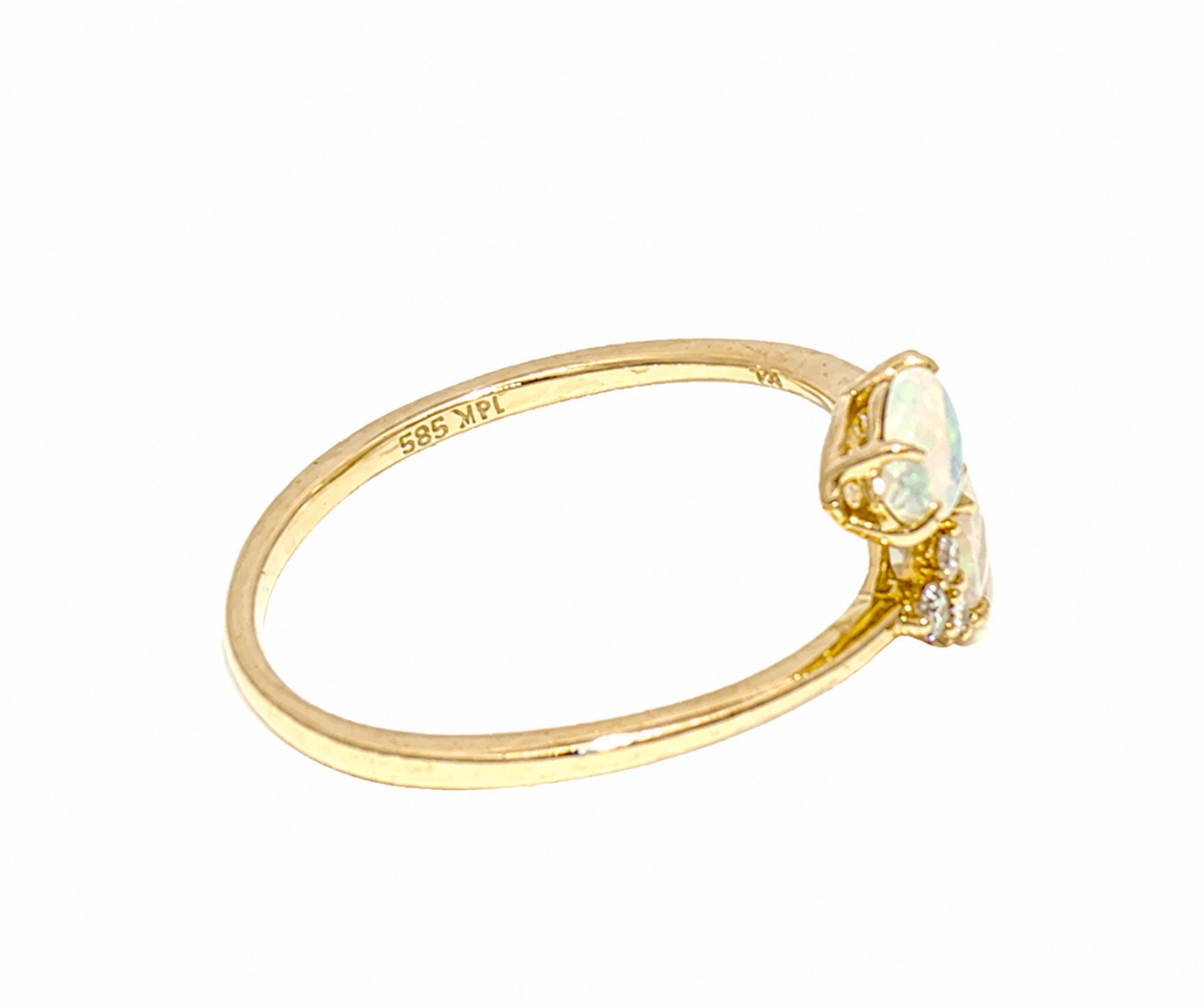 A yellow gold ring featuring a small white opal and a clear accent stone, shown on a plain white background. 