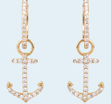 Gold anchor-shaped earrings with clear stones on a light blue background
