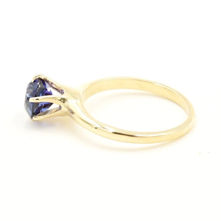 Estate 14k YG Blue Sapphire Solitaire Ring by Kent Island Jewelry, shown from the side on a white background.