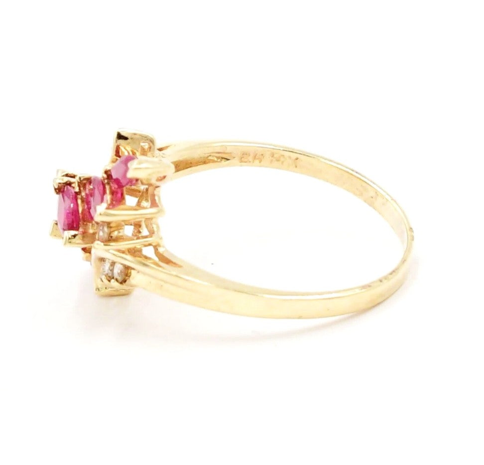 Kent Island Jewelry Estate 14k yellow gold ring with rubies and .08ctw diamonds, shown from an angled side view.