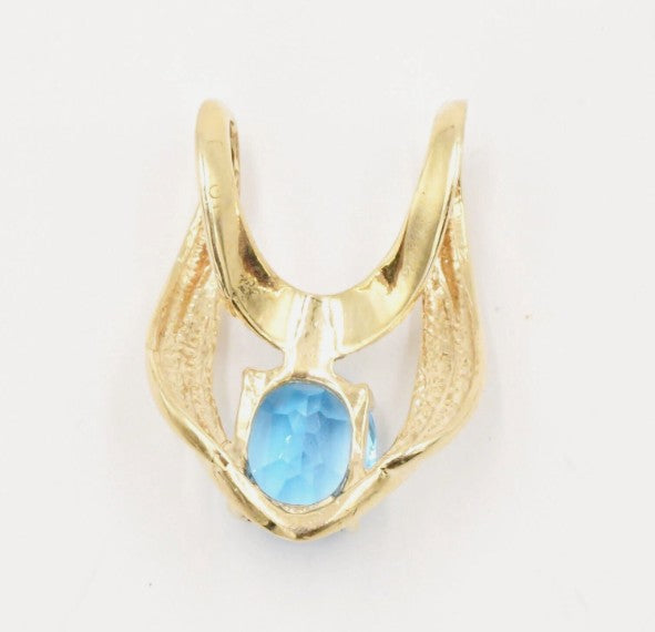 Gold pendant with a topaz stone on a white background