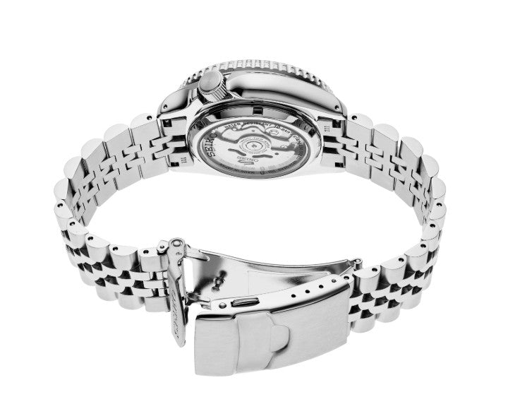 Seiko 5 Sports SKX Sports Style GMT watch with a silver open metal bracelet and transparent caseback displaying its movement.