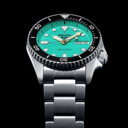 Seiko 5 Sports SS Automatic watch with a green dial, silver strap, black bezel, and day-date display.