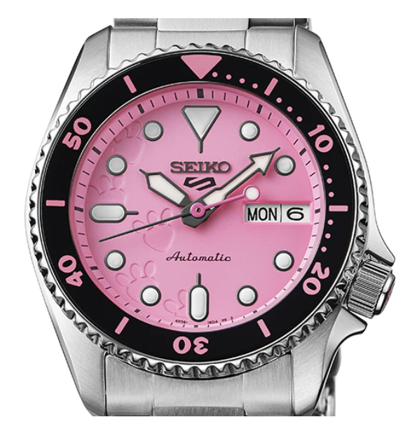 A Seiko women's automatic watch featuring a pink dial, pink hour markers, a black rotating bezel, and a stainless steel link bracelet.