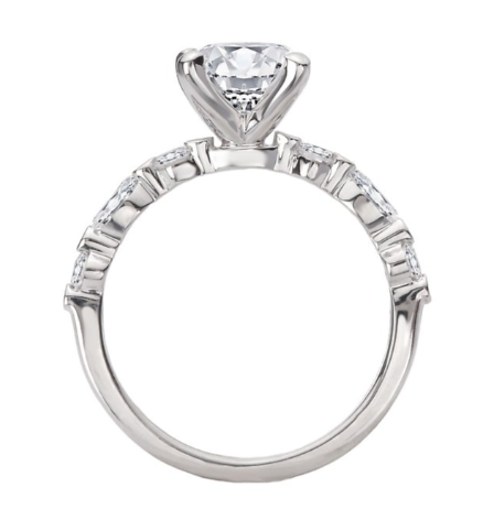 The Romance Semi-Mount Diamond Engagement Ring features a round solitaire and baguette accents in white gold.