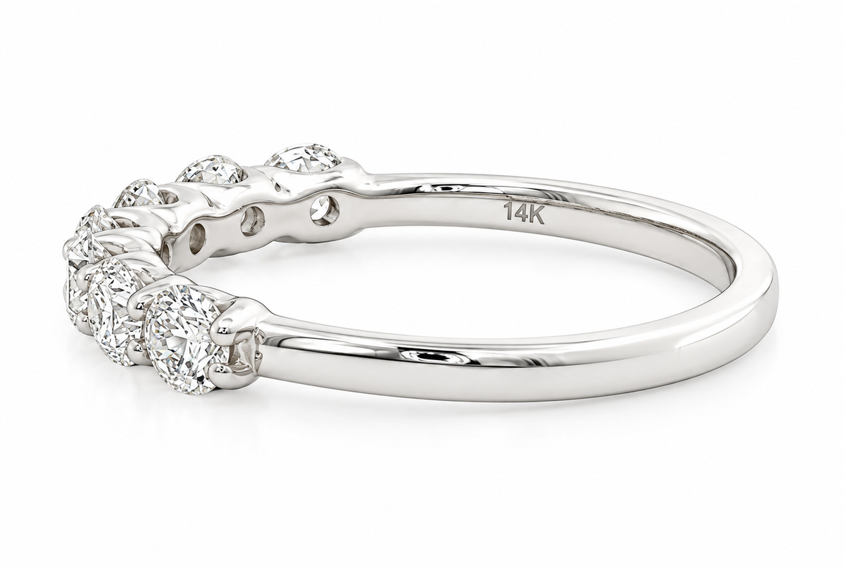 A polished white gold diamond band ring with a curved row of round-cut diamonds on the front, shown on a clean white background. 