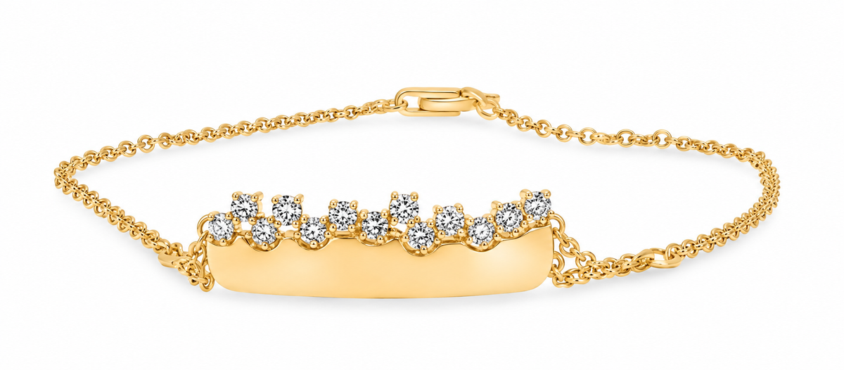 A yellow gold bracelet featuring a polished horizontal bar adorned with a row of small diamonds, set on a delicate gold chain with a lobster clasp, shown on a white background.