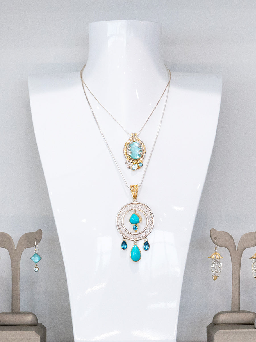 Jewelry set with turquoise stone pendant necklaces on a mannequin against a white background