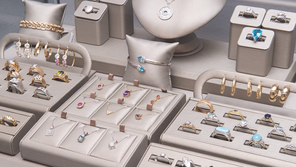 Jewelry display with rings, earrings, bracelets and more on a light surface