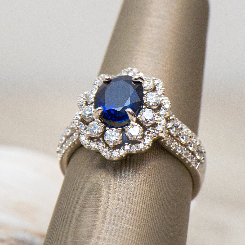 Elegant ring with a blue gemstone and diamond accents on a neutral background